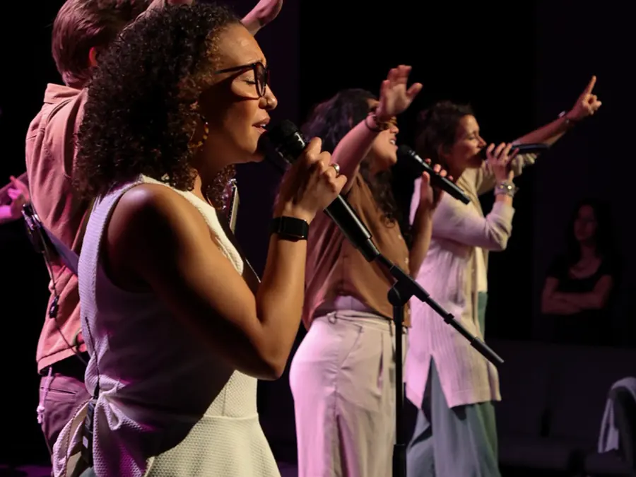 Tres coristas cantando juntas en la plataforma